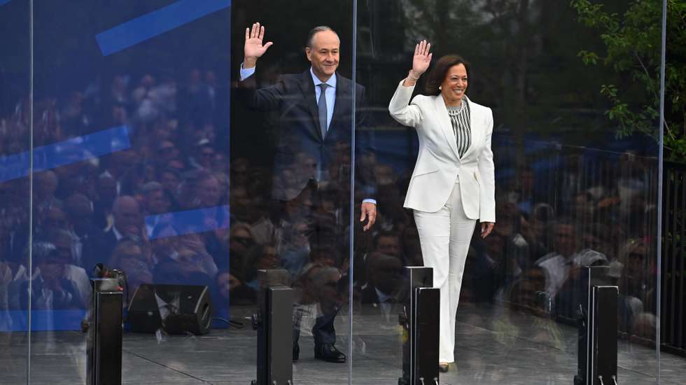 epa13047397 Former US Vice President Kamala Harris and second gentleman Doug Emhoff wave as they step onto the main stage during the opening ceremony at the Obama Presidential Center in Chicago, Illinois, USA, 18 June 2026. The Obama Presidential Center in Chicago will serve as a civic hub, museum, library, and education project commemorating the presidency of Barack Obama.  EPA/VICTOR HILITSKI