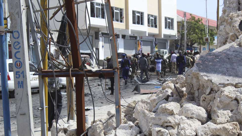 epa08111823 Rubbles are seen as people gather at the scene of a suicide car bomb explosion at a checkpoint near the parliament in Mogadishu, Somalia, 08 January 2019. At least four people have been killed in a latest attack claimed by Somalia's Islamist militant group al-Shabab.  EPA/SAID YUSUF WARSAME