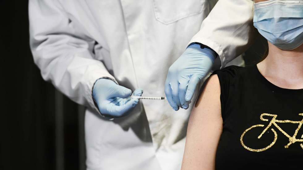 epa08958439 A general practitioner is given the first injection of a vaccine against coronavirus Covid-19 in the Medisch Spectrum Twente in Enschede, the Netherlands, 22 January 2021. A total of 15,000 people are eligible for this vaccination round. The GP's are all getting Moderna's vaccine against Covid-19.  EPA/PIROSCHKA VAN DE WOUW