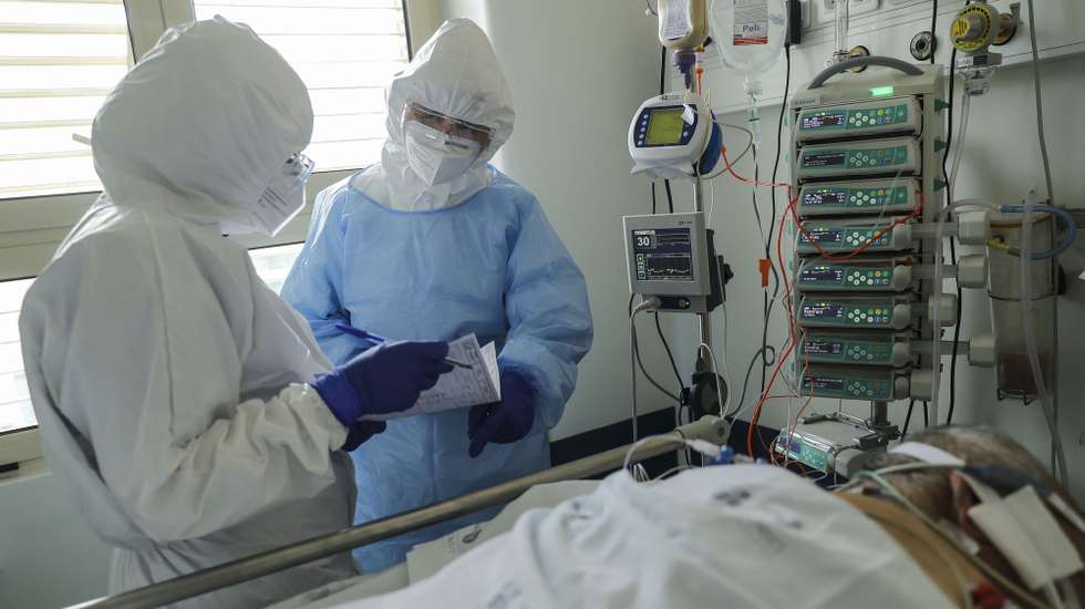 Dois elementos da equipa médica cuidam de um paciente hospitalizado na Unidade de Cuidados Intensivos covid-19 do Hospital Santa Maria, em Lisboa, 11 de fevereiro de 2021. O Hospital Santa Maria conta ao dia de hoje com 271 doentes internados com  64 destes doentes internados nos Cuidados Intensivos covid-19, o número máximo atingido até ao dia de hoje neste Hospital. (ACOMPANHA TEXTO DA LUSA DO DIA 14 DE FEVEREIRO DE 2021). MIGUEL A. LOPES/LUSA