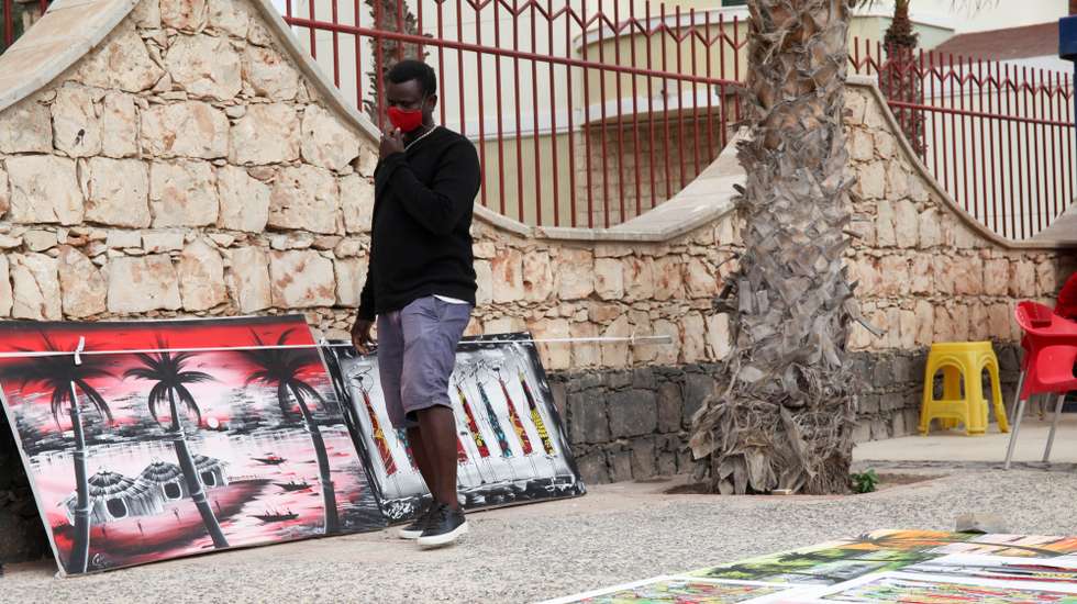 Faustino Lopes, de 36 anos, trocou em 2017 o trabalho nas obras em Bafatá, Guiné-Bissau, para viver da paixão pela pintura, e agora com a pandemia de covid-19 a dar tréguas em Cabo Verde, voltou a expor as dezenas de quadros que foi acumulando, junto ao calçadão da praia em Santa Maria, ilha do Sal, Cabo Verde, 11 de fevereiro de 2021. Artesãos e artistas africanos mantêm, por estes dias, o ritual, expondo os trabalhos pelas ruas de Santa Maria, ilha do Sal, procurando chamar a atenção dos poucos turistas, após vários meses sem negócio sobrevivendo de poupanças. (ACOMPANHA TEXTO DA LUSA DO 20 DE FEVEREIRO DE 2021). FERNANDO DE PINA/LUSA
