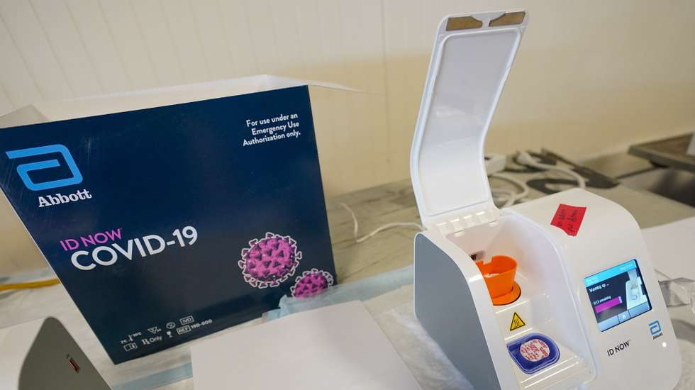 epa09135790 An Abbott ID NOW COVID-19 rapid tester is seen during an event with New York Governor Andrew Cuomo at a pop-up vaccination site at the Belmont Park Redevelopment Project in Elmont, New York, USA, 14 April 2021.  EPA/MARY ALTAFFER / POOL