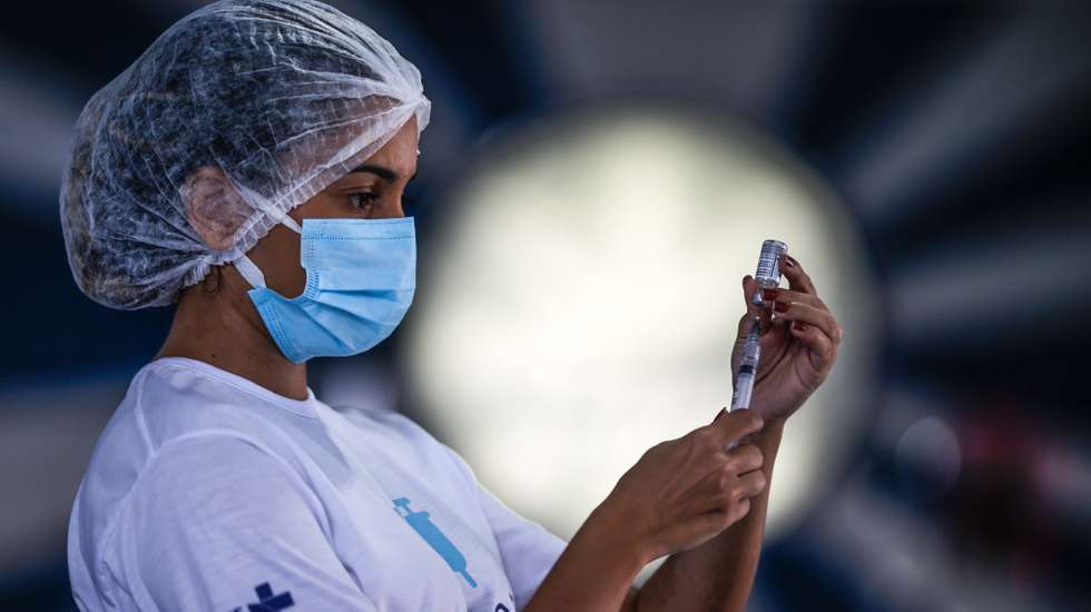 epa09148192 A health worker prepares doses of the Astrazeneca vaccine against covid-19 today, in the block of Portela, one of the most traditional carnival groups in Rio de Janeiro, Brazil 20 April 2021. Brazil is the second country with the most deaths, behind the United States, although it is currently the place on the planet where most people die from covid-19. In terms of infections, the South American power is located in third place, after the US and India.  EPA/Andre Coelho