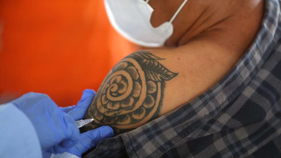 epa09258905 A health care officer injects a dose of AstraZeneca (Vaxzevria) COVID-19 vaccine to a man during mass vaccination drive in Jakarta, Indonesia, 10 June 2021. The Jakarta administration started a COVID-19 vaccination drive for people aged 18 and above due to an increasing number of coronavirus (COVID-19 disease) cases. Indonesia has recorded more than 1,800,000 COVID-19 cases since the beginning of the pandemic.  EPA/Bagus Indahono
