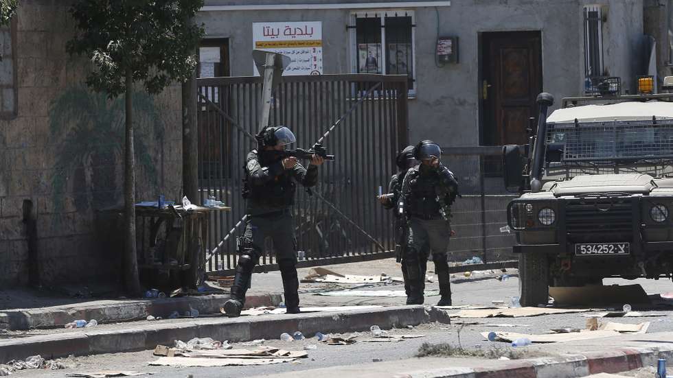 epa09282952 Israeli soldiers take position during clashes with Palestinian protesters after a protest against Israeli settlements at Beta village near the West Bank City of Nablus, 18 June 2021. According to Medical sources, 57 Palestinians were wounded during the clashes.  EPA/ALAA BADARNEH
