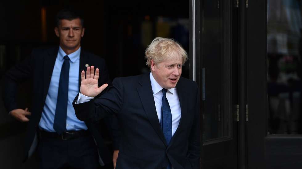 epa09502947 Britain's Prime Minster Boris Johnson (R) departs his hotel for media engagements during the first day of his political party's annual conference in Manchester, Britain, 03 October 2021. The Conservative Party Conference runs from 03 to 06 October 2021.  EPA/NEIL HALL