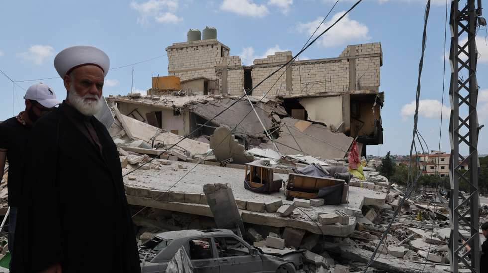 epa13039566 A sheikh who has returned to his village stands next to a destroyed building following an Israeli strike in the village of Maaroub, southern Lebanon, 15 June 2026, after the announcement of a US-Iran mediated preliminary framework to end regional military hostilities and lift the naval blockade on the Strait of Hormuz.  EPA/WAEL HAMZEH