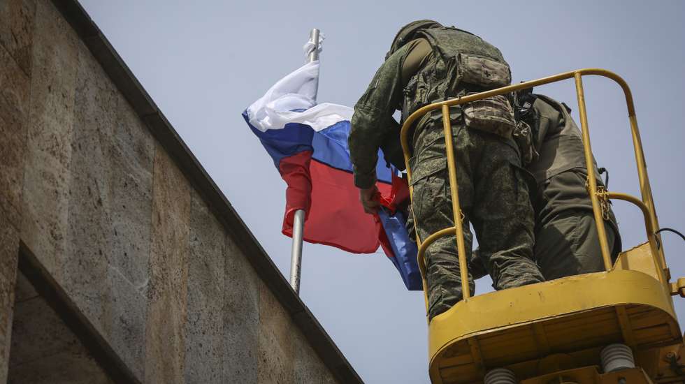 epaselect epa09978484 Igor Zakharevich (L), the militant-appointed mayor of Debaltseve, arranges the flags of Russia and the self-proclaimed Donetsk People's Republic at the city administration building of Svitlodarsk, Donetsk region, Ukraine, 26 May 2022. Russia has taken control of the city of Svetlodarsk, located 80 km southwest of Severodonetsk, which was the center of Russian attacks in recent days. On 24 February Russian troops had entered Ukrainian territory in what the Russian president declared a 'special military operation', resulting in fighting and destruction in the country and a humanitarian crisis.  EPA/ALESSANDRO GUERRA