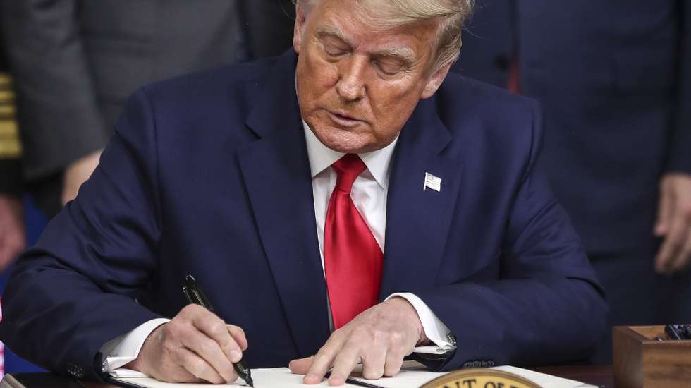 epa08871446 US President Donald J. Trump signs an executive order giving priority to Americans to receive American coronavirus vaccines during the Operation Warp Speed Vaccine Summit in the Eisenhower Executive Office Building at the White House in Washington, DC, USA,  on 08 December 2020.  EPA/Oliver Contreras / POOL