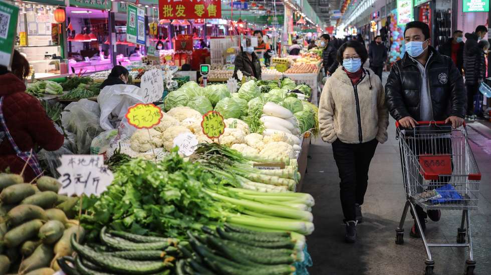 epa08871803 Consumers walk past vegetable stalls at a stall at a market in Beijing, China, 09 December 2020. According to the National Bureau of Statistics, China's Consumer Price Index (CPI), which is a main gauge of inflation, down 0.5 percent year-on-year in November 2020 that posted the first year-on-year drop in 11 years.  EPA/WU HONG