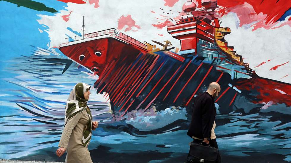 epa12901960 Iranians walk past an anti-USA and anti-Israel mural on a street in Tehran, Iran, 20 April 2026. Conflict between Iran and the US over the Strait of Hormuz continues as Iran again closed the strait, as the Iranian foreign ministry spokesman said on 20 April that Iran has no plan to participate in Pakistan talks with the US yet.  EPA/ABEDIN TAHERKENAREH