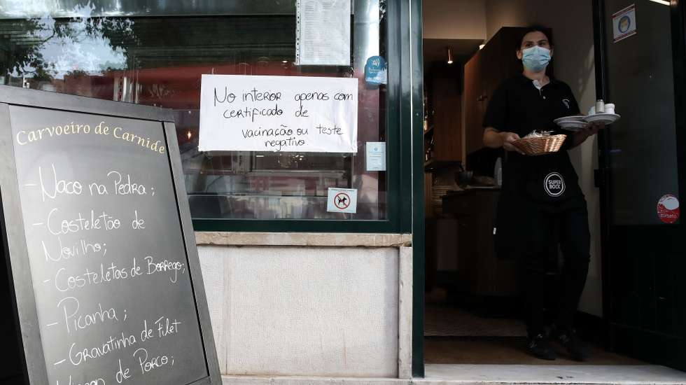 Aviso sobre certificado digital ou teste à entrada de um restaurante em Lisboa, após o Governo decreta que os restaurantes em concelhos de risco elevado ou muito elevado – um total de 60 – passam a ter de exigir certificado digital ou teste negativo à covid-19 a partir das 19:00 de sexta-feira e aos fins de semana para refeições no interior, Lisboa, 10 de julho de 2021. As pessoas em esplanadas que precisarem de entrar nos restaurantes para acesso aos serviços comuns, como instalações sanitárias, ou para efetuarem pagamento, estão dispensadas de apresentar um teste negativo à covid-19 ou o certificado digital. MANUEL DE ALMEIDA/LUSA