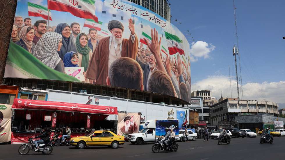 epa12918543 Iranians drive past a huge billboard carrying a picture of the late Iranian Supreme Leader Ayatollah Ali Khamenei in Tehran, Iran, 28 April 2026. US President Donald Trump announced that a ceasefire between the US and Iran has been extended.  EPA/ABEDIN TAHERKENAREH