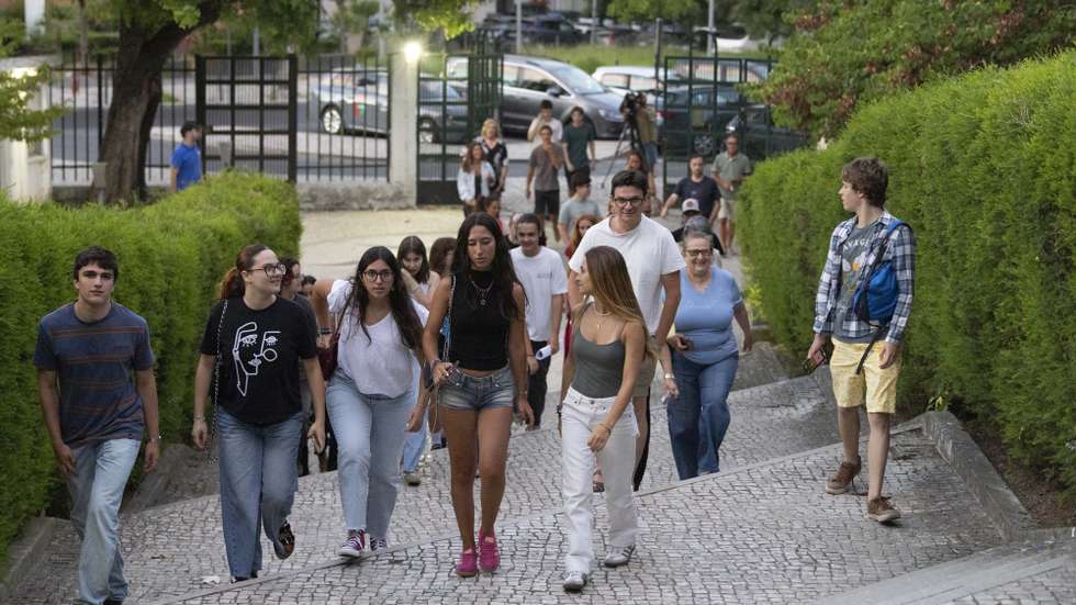 Estudantes à chegada para consultarem as pautas com as notas das provas finais do 11.º e 12.º ano, na escola secundária José Gomes Ferreira, em Lisboa, 17 de julho de 2026. Devido às dificuldades informáticas no processo de classificação eletrónica, que “pressionaram o cumprimento do calendário inicialmente previsto”, o Ministério da Educação, Ciência e Inovação decidiu ajustar o calendário da avaliação externa para garantir aos alunos a qualidade e o rigor do processo e assegurar aos professores o tempo necessário e adequado para a classificação dos itens das provas. ANTÓNIO COTRIM/LUSA