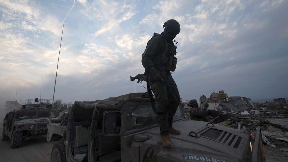 epaselect epa11018178 A photo taken while embedded with the Israel Defense Forces (IDF) shows an Israeli soldier standing on the hood of a military vehicle at a position in the Palestinian town of Beit Lahia, on the outskirts of the city of Gaza, northern Gaza Strip, 08 December 2023. Israeli forces resumed military strikes on Gaza after a week-long truce expired on 01 December. More than 16,200 Palestinians and at least 1,200 Israelis have been killed, according to the Palestinian Health Ministry and the Israel Defense Forces (IDF), since Hamas militants launched an attack against Israel from the Gaza Strip on 07 October, and the Israeli operations in Gaza and the West Bank which followed it. The Israeli military stated that its forces are involved in 'ground operations' against Hamas in the Gaza Strip, including the south of the enclave.  EPA/ATEF SAFADI