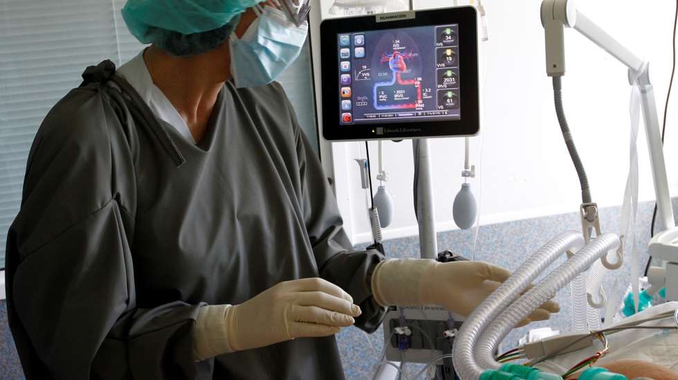 epa09079779 Health workers attend a Covid-19 patient at Ferrol Universitary Hospital in Ferrol, Galicia, Spain, 17 March 2021. Spain on 16 March recorded 141 deaths, 4,962 new cases and an impact during the last 14 days of 127.8 cases for 100,000 inhabitants.  EPA/Kiko Delgado