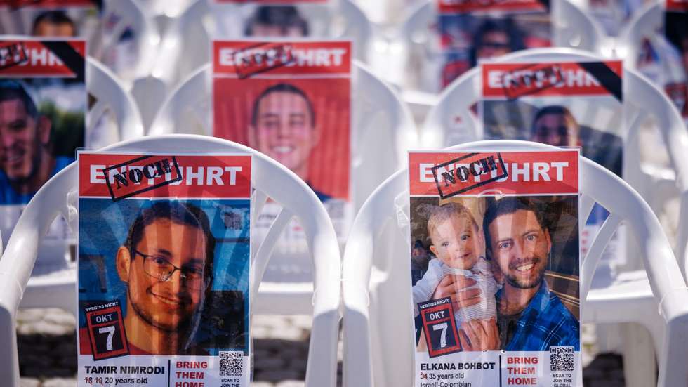 epa12062301 Placards with portraits of unreleased Israeli hostages, still assumed to be held in Hamas captivity, rest on chairs on Bebel Platz square in Berlin, Germany, 29 April 2025. The installation, which will be opened on the evening of 29 April 2025, shows 59 empty chairs with placards and portraits of Israeli hostages still in Hamas captivity.  EPA/CLEMENS BILAN