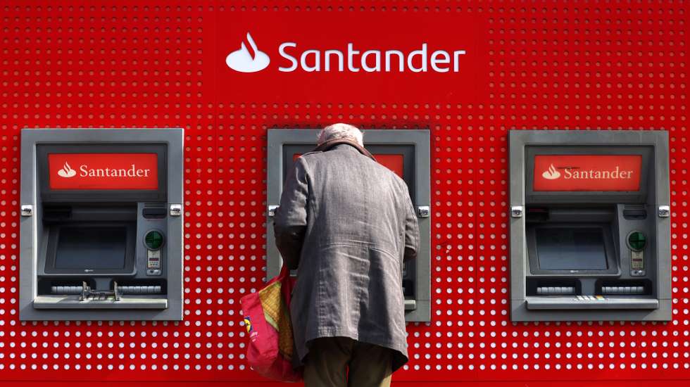 epaselect epa11973776 A customer uses a Santander ATM machine in London, Britain, 19 March 2025. Santander has announced it plans to close some 95 bank branches across the UK, which will put 750 jobs at risk.  EPA/ANDY RAIN