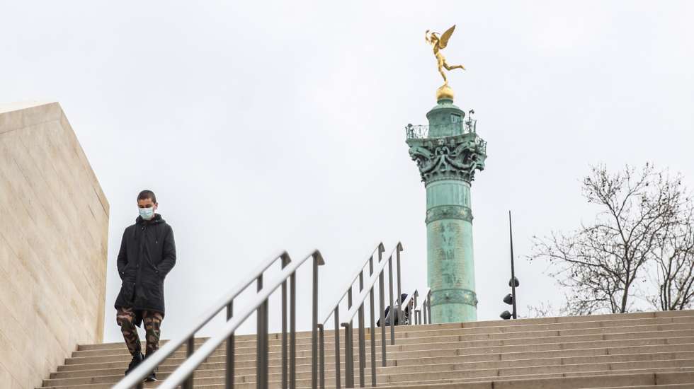 epa09081675 A man wearing face masks walk in Place de la Bastille in Paris, France, 18 March 2021. Prime Minister Jean Castex will held a press conference on 18 March 2021 to detail the new virus restrictions in Paris region and in the north of France as the number of COVID-19 patients in intensive care units spikes.  EPA/Mohammed Badra