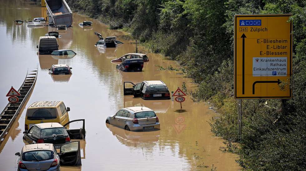 epaselect epa09351311 Wrecked cars and trucks are flooded on the B265 federal highway in Erftstadt, Germany, 17 July 2021. Large parts of Western Germany were hit by heavy, continuous rain in the night to Wednesday, resulting in local flash floods that destroyed buildings and swept away cars.  EPA/SASCHA STEINBACH
