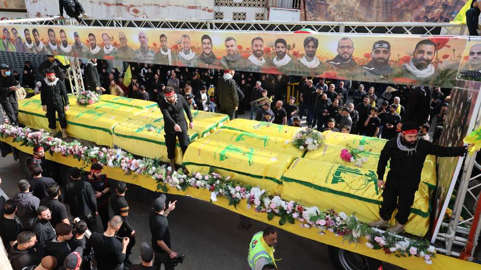 epa12904831 People gather around coffins of Hezbollah fighters, who were killed before the ceasefire between Hezbollah and Israel, during a mass funeral procession in Kfar Sir village, southern Lebanon, 21 April 2026. Hezbollah announced in a statement it will hold a mass funeral in Kfar Sir for 29 people killed in the conflict with Israel before the 10-day ceasefire took effect.  EPA/WAEL HAMZEH