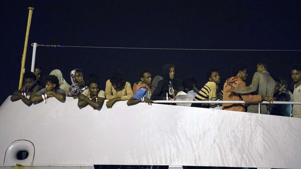 epaselect epa06892463 Migrants wait to disembark from the Frontex ship, 'Protector', at the port of Pozzallo, Sicily, Italy, early 16 July 2018. Nearly 450 migrants were rescued on 14 July, near the island of Linosa by the Italian Patrol Boat 'Monte Sperone' and the European Border and Coast Guard Agency ship 'Protector'.  EPA/FRANCESCO RUTA