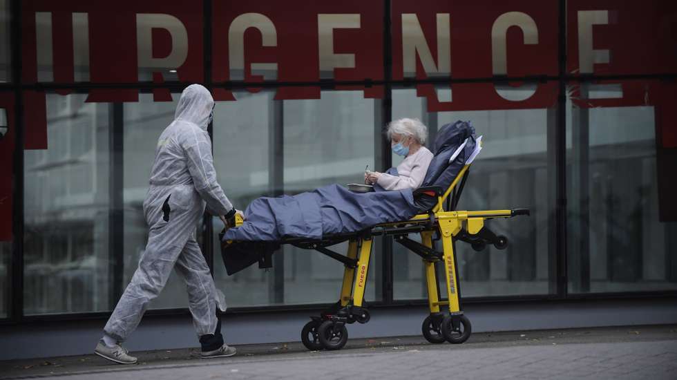 epa08780294 Medical staff wearing protective facial masks transport a patient on a gurney inside the Tenon Hospital in Paris, France, 28 October 2020. French President Emmanuel Macron will unveil new measures to stem the Covid-19 epidemic in a television speech on 28 October 2020.  EPA/JULIEN DE ROSA