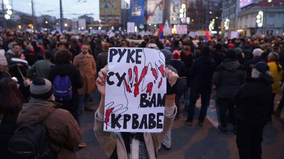 epa11790063 A protester raises a sign reading 'Your hands are bloodied' during a protest rally in Belgrade, Serbia, 22 December 2024. University students and farmers called on a protest asking for accountability after fifteen people lost their lives in the collapse of the Novi Sad Railway Station canopy on 01 November 2024. The station building, which had been renovated and reopened on 05 July 2024, was undergoing further renovations shortly before the collapse.  EPA/ANDREJ CUKIC
