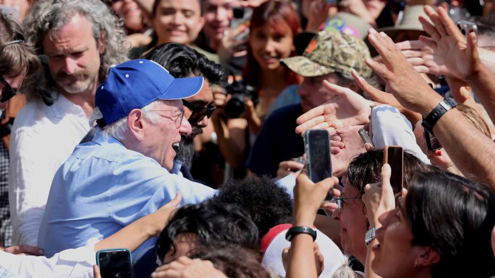 epa12028304 US Senator Bernie Sanders (L) greets supporters after delivering a speech on stage during the 'Fighting Oligarchy Tour' rally at Grand Park in Los Angeles, California, USA, 12 April 2025. Thousands of people attended the rally, at which music artists Neil Young and Joan Baez performed.  EPA/DAVID SWANSON