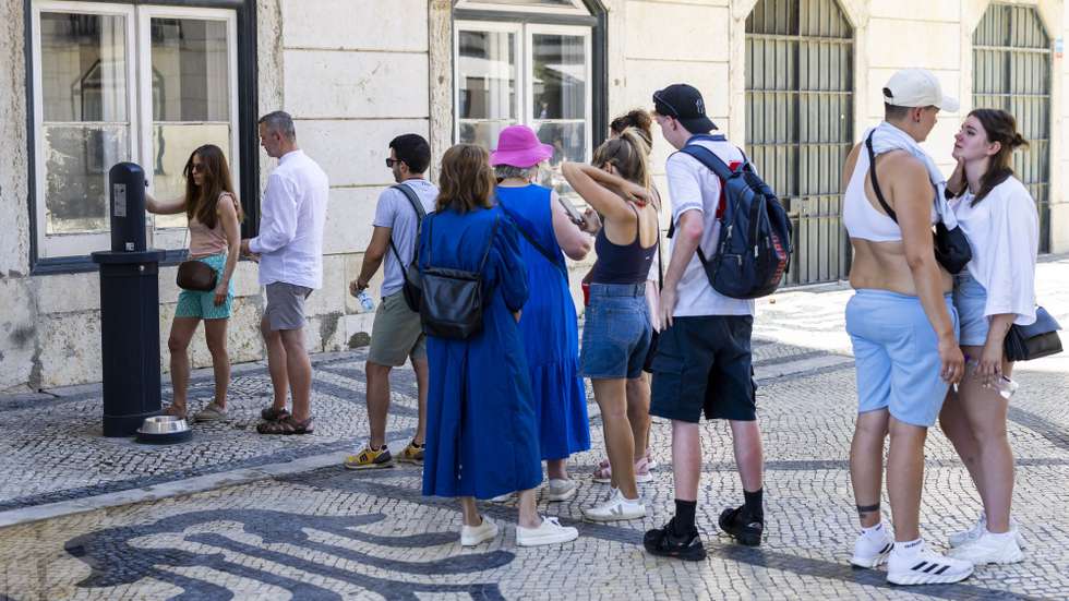 epa13080353 People wait in line to fill up their water bottles during a heatwave in downtown Lisbon, Portugal, 02 July 2026. The national weather agency (IPMA) has issued high-level red alerts due to a spell of extreme heat that is expected to last for at least a week.  EPA/JOSE SENA GOULAO