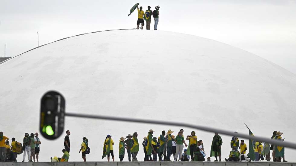 epaselect epa10396404 Bolsonaro supporters walk on the dome of the National Congress, in Brasilia, Brazil, 08 January 2023. Hundreds of supporters of former Brazilian President Jair Bolsonaro invaded the headquarters of the National Congress, and also Supreme Court and the Planalto Palace, seat of the Presidency of the Republic, in a demonstration calling for a military intervention to overthrow President Luiz Inacio Lula da Silva. The crowd broke through the cordons of security forces and forced their way to the roof of the buildings of the Chamber of Deputies and the Senate, and some entered inside the legislative headquarters.  EPA/ANDRE BORGES