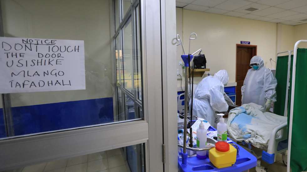 epa08857796 Kenyan medical staffs (R) wearing Personal Protective Equipment (PPE) gear check on a patient put on an oxygen machine inside an Intensive Care Unit for COVID-19 patients at the Machakos Level 5 hospital in Machakos, Kenya, 02 December 2020. Kenya continues to record high numbers of confirmed new COVID-19 cases on community transmission with fears that the infections will go high towards the festive seasons as people travel more upcountry. Kenyan President Kenyatta announced on 04 November 2020 the extension of a nationwide COVID-19 curfew from 10pm to 4am until 03 January 2021 and the ban of political rallies for 60 days as coronavirus infections surged.  EPA/DANIEL IRUNGU  ATTENTION: This Image is part of a PHOTO SET