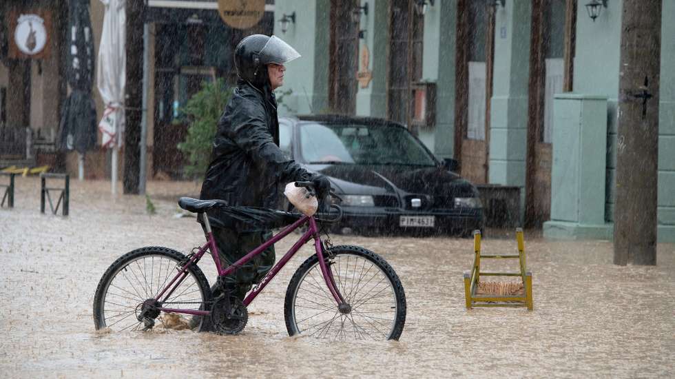 epa10842337 A man walks his bike through a flooded road during the storm named Daniel in the area of Volos, Magnesia, Greece, 05 September 2023. A man died as unprecedented bad weather conditions have stricken the region of Magnesia and the city of Volos on 05 September. Meanwhile, the region of Magnesia was faced with heavy storm overnight which lasted for over 10 hours and the phenomena are expected to continue until 06 September.  EPA/HATZIPOLITIS NICOLAOS