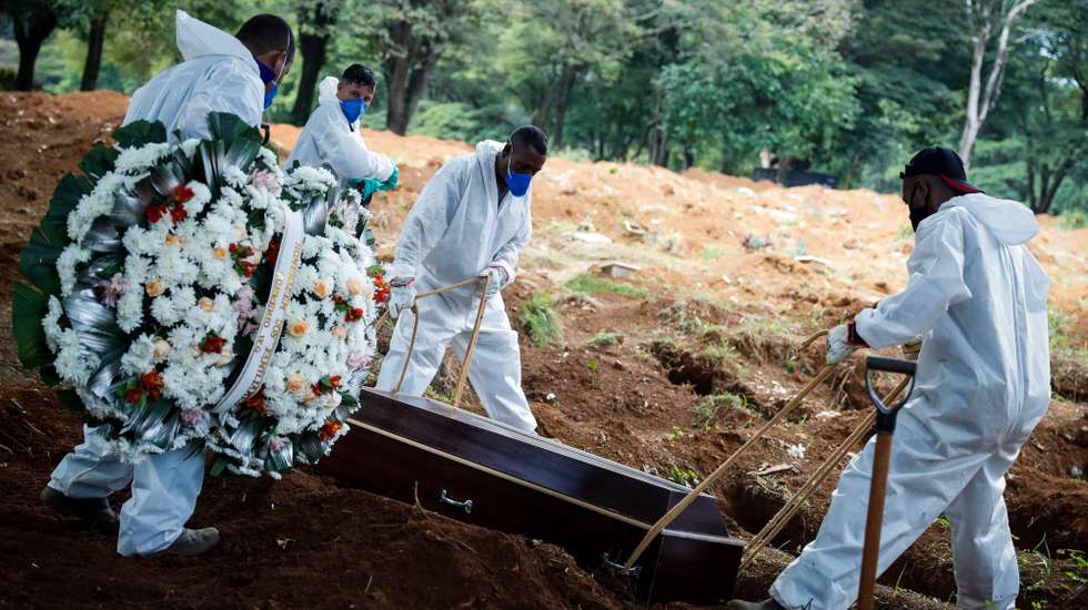 epa09069793 Workers carry out the burial of a covid-19 victim at the Vila Formosa Cemetery, in Sao Paulo, Brazil, 11 March 2021 (issued 12 March 2021). A year since the first death from covid-19, Brazil still fights with the pandemic with public hospitals at a 'very critical' point and cemeteries with gravediggers at the limit of their strength in the middle of the second wave. Against the global trend of stabilization, Brazil presents the worst scenario since the beginning of the pandemic and is currently the place on the planet that registers the most cases and deaths from coronavirus daily, above the United States. The last two days it has exceeded the 2,000 daily death mark.  EPA/FERNANDO BIZERRA