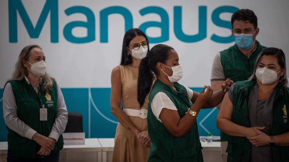 epa08950549 The nursing technician Rosenira Magalhaes receives the vaccine against covid-19 during a ceremony at the Mayor's Office of Manaus, Amazonas state, Brazil, 19 January 2021. Rosenira Magalhaes became the first person to be vaccinated in the vaccination campaign against covid-19, in the municipality of Manaus, in the Brazilian state of Amazonas, which has experienced a serious health collapse since last week due to the growing number of infections and deaths due the pandemic.  EPA/RAPHAEL ALVES