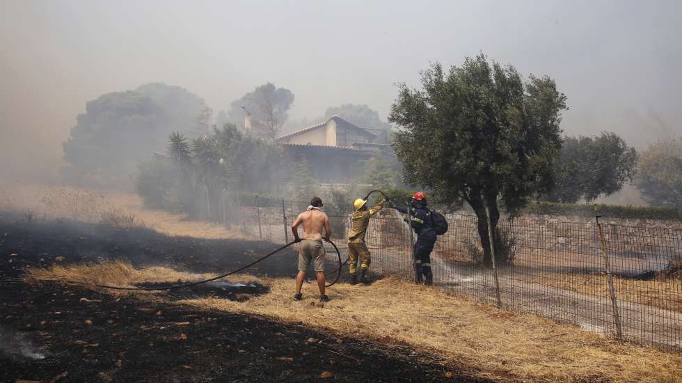epa09416330 Firefghters and volunteers battle blazes raging near a house during a wildfire that broke out in the area of Keratea, some 40 km away from Athens city, Greece, 16 August 2021. Three settlements in the area of Keratea have been evacuated and the traffic in the area has been interrupted. Meanwhile, another wildfire broke out at a forest area in Villia, Attica region.  EPA/ALEXANDROS VLACHOS