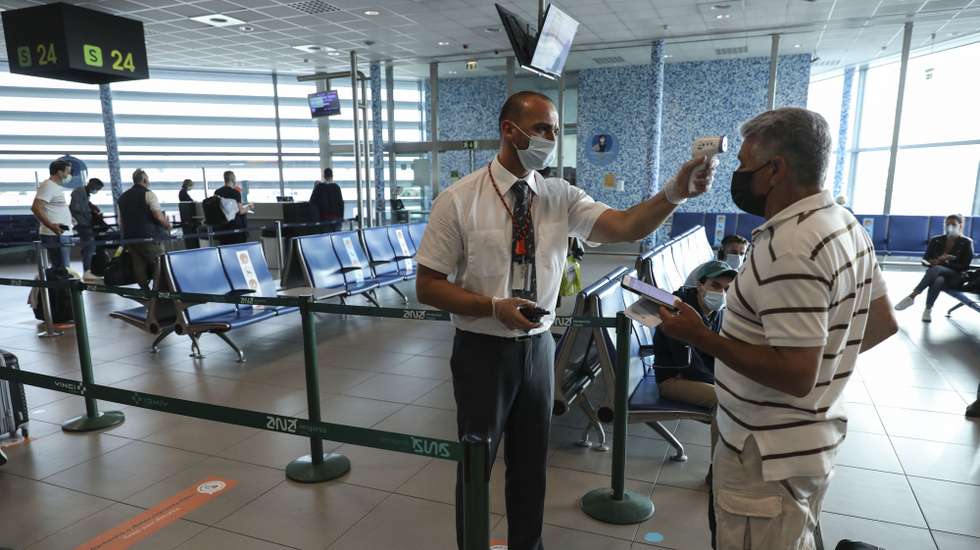 Um funcionário do Aeroporto de Lisboa mede a temperatura a um passageiro antes deste embarcar num voo da Transavia para Nantes na retoma desta rota, no dia de atribuição do selo do Turismo de Portugal Clean &amp; Safe ao Aeroporto de Lisboa, 15 de junho de 2020. O selo distingue as atividades turisticas e outras relacionadas com o setor, que asseguram os requisitos de higiene e limpeza para prevenção e controlo da Covid-19. MIGUEL A. LOPES/LUSA