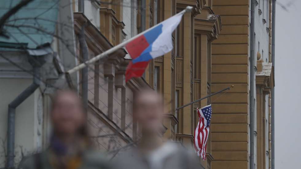 epa09137644 A Russian flag (L) next to the US embassy building in Moscow, Russia, 15 April 2021. Tensions have escalated between the US and Russia following the new sanctions announced by the United States against Russia.  EPA/MAXIM SHIPENKOV