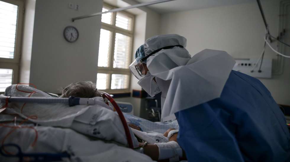 Uma enfermeira cuida de um paciente hospitalizado na Unidade de Cuidados Intensivos Covid 19 do Hospital Santa Maria em Lisboa, 27 de outubro de 2020. A urgência dedicada aos casos suspeitos de covid-19 do Hospital Santa Maria, em Lisboa, reflete a evolução da pandemia em Portugal com doentes a avolumarem-se à porta para realizar o teste e no interior a capacidade quase esgotada. O medo de perder o emprego leva muitos doentes com covid-19 a esconderem que estão infetados e a continuar a trabalhar, disseminando a doença que, nesta fase, começa a ser um caso também social e que leva a muitos internamentos no Santa Maria. (ACOMPANHA TEXTO DA LUSA DE 30 DE OUTUBRO DE 2020) TIAGO PETINGA/LUSA