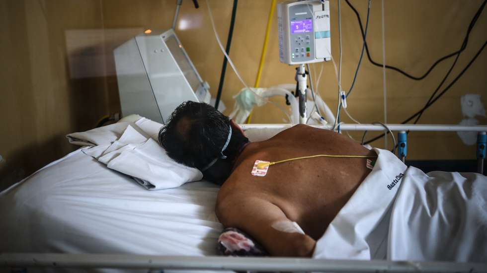 epa09175903 A pacient lies on bed as medical staff work at an intensive care unit in a hospital in Buenos Aires, Argentina, 28 April 2021 (issued 03 May 2021). Argentina enters a new stage of measures to stop the second wave of covid-19 and avoid health chaos, which include older people restrictions, especially in the metropolitan area of Buenos Aires, the most affected by the virus.  EPA/Juan Ignacio RONCORONI