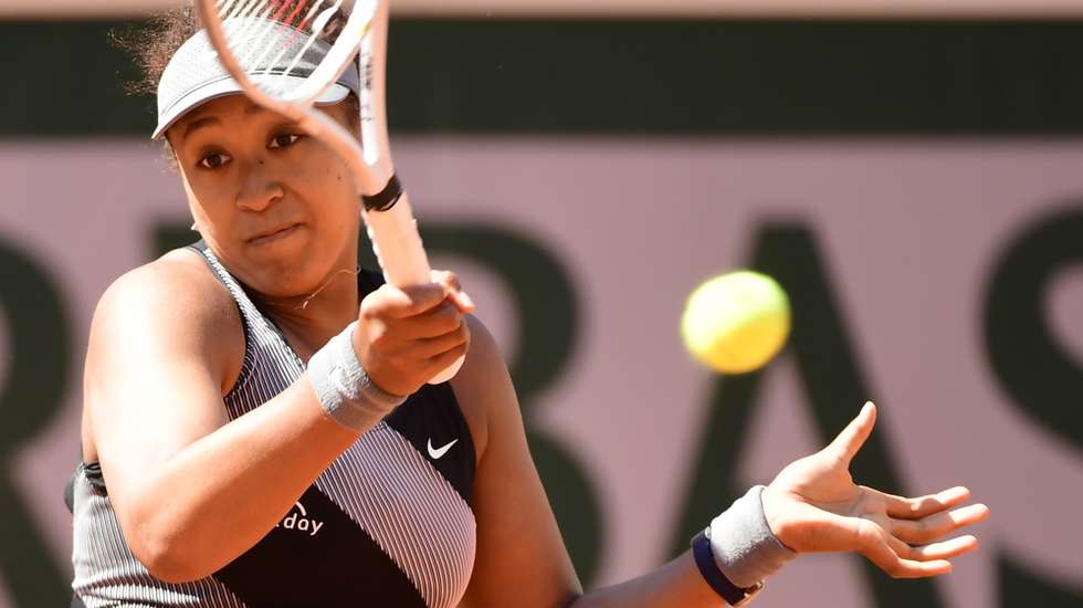 epa09236559 Naomi Osaka of Japan in action against Patricia Maria Tig of Romania during their first round match at the French Open tennis tournament at Roland ​Garros in Paris, France, 30 May 2021.  EPA/CAROLINE BLUMBERG