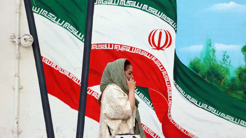 epa12121608 An Iranian woman walks past a wall painting of Iran's national flag in Tehran, Iran, 21 May 2025. Iran and US talks have paused as both sides made remarks against each other in recent days. According to the Iranian Foreign Ministry, Iranian Foreign Minister Abbas Araghchi said on 21 May 2025 that they are evaluating whether to participate in the next round of negotiations. He added that Iran has already responded to unreasonable demands and that such remarks do not help the talks. Our position is clear: uranium enrichment will continue, whether or not there is an agreement.  EPA/ABEDIN TAHERKENAREH
