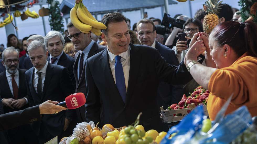 O primeiro-ministro, Luís Montenegro (C), cumprimenta uma vendedora à chegada ao Mercado do Bolhão para presidir ao Conselho de Ministros, no Porto, 02 de abril de 2025. JOSÉ COELHO/LUSA