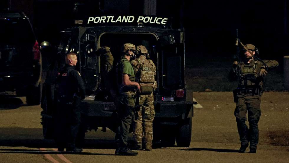 epa10939848 Police officers surround an armored law enforcement vehicle parked on the parking lot of the Lisbon High School gymnasium as an active search for the shooter is underway following a mass shooting during which a man on late 25 October reportedly opened fire this evening killing and injuring numerous people in Lewiston, in Lisbon, Maine, USA, 26 October 2023. Early reports on 25 October, indicate multiple fatal casualties, and dozens of injured. Police are still searching for the suspect and county officials have declined to give answers regarding the number of the victims so far.  EPA/CJ GUNTHER