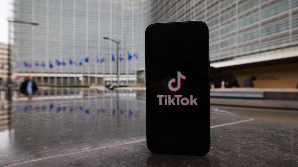 epa12708585 A TikTok logo is seen in front of the headquarters of the European Commission in Brussels, Belgium, 06 February 2026. EU authorities continue to scrutinize TikTok under digital regulation rules concerning transparency, access to platform data, content moderation, advertising practices, and the platform's impact on public debate and elections.  EPA/OLIVIER HOSLET