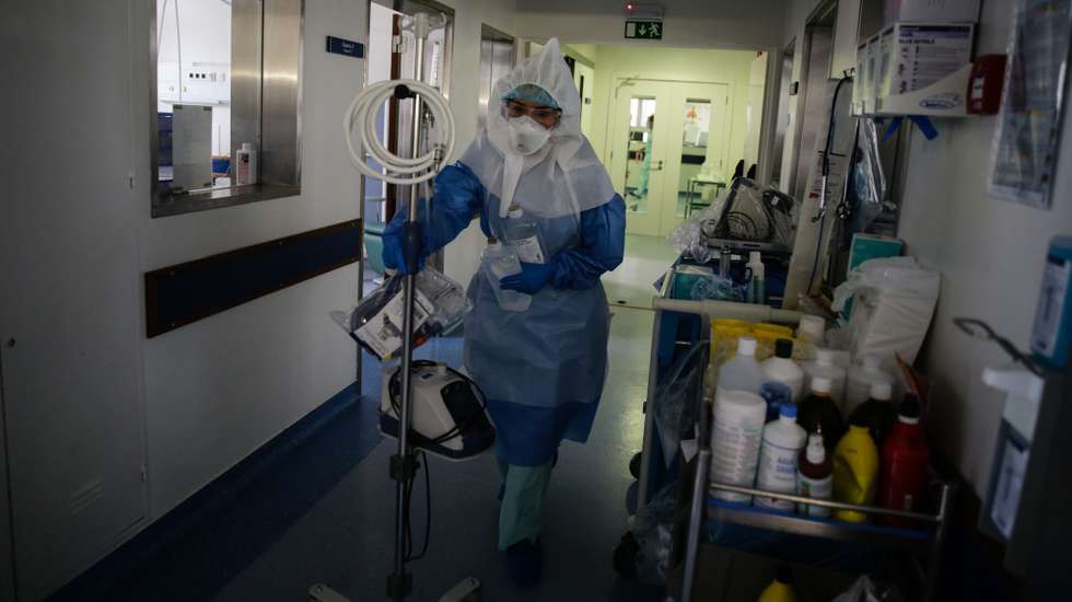 Uma enfermeira transporta material de apoio num dos corredores da Unidade de Cuidados Intensivos Covid 19 do Hospital Santa Maria em Lisboa, 27 de outubro de 2020. A urgência dedicada aos casos suspeitos de covid-19 do Hospital Santa Maria, em Lisboa, reflete a evolução da pandemia em Portugal com doentes a avolumarem-se à porta para realizar o teste e no interior a capacidade quase esgotada. O medo de perder o emprego leva muitos doentes com covid-19 a esconderem que estão infetados e a continuar a trabalhar, disseminando a doença que, nesta fase, começa a ser um caso também social e que leva a muitos internamentos no Santa Maria. (ACOMPANHA TEXTO DA LUSA DE 30 DE OUTUBRO DE 2020) TIAGO PETINGA/LUSA