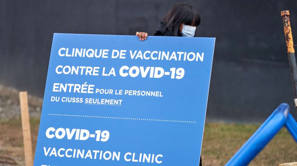 epa08883886 Workers set up signs at the first center to recive Covid-19 vaccine in Montreal, Canada, 14 December 2020. The first patients in Canada will be vaccinated there with the Pfizer BionNtech vaccine.  EPA/ANDRE PICHETTE