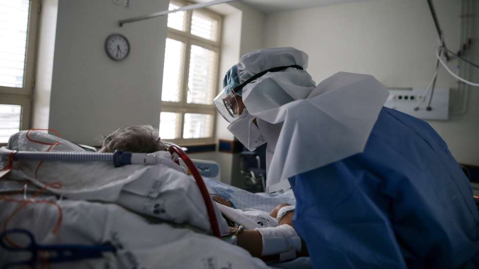 epa08785451 A nurse caring for a pacient at the Covid 19 Emergency Department of Santa Maria Hospital in Lisbon, Portugal, 27 October 2020 (issued 30 October 2020). The emergency room dedicated to suspected covid-19 cases at Santa Maria Hospital in Lisbon reflects the evolution of the pandemic in Portugal with patients swelling at the door to perform the test and inside the almost exhausted capacity. The fear of losing their jobs leads many patients with covid-19 to hide that they are infected and continue working, spreading the disease that, at this stage, also begins to be a social case and that leads to many hospitalizations in Santa Maria.  EPA/TIAGO PETINGA