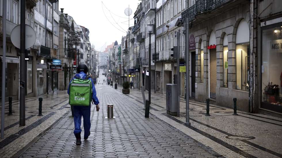 Um trabalhador de entregas ao domicílio na Rua de Santa Catarina durante o recolher obrigatório do estado de emergência no âmbito das medidas de contenção da covid-19, no Porto, 15 de novembro de 2020. Com 191 concelhos em risco em Portugal, o Conselho de Ministros decretou o encerramento de todos os estabelecimentos comerciais e restauração a partir das 13h00 até às 08h00 do dia seguinte, tanto no sábado como no domingo, para além do confinamento obrigatório para toda a população dos concelhos em risco a partir das 13h. MANUEL FERNANDO ARAÚJO/LUSA