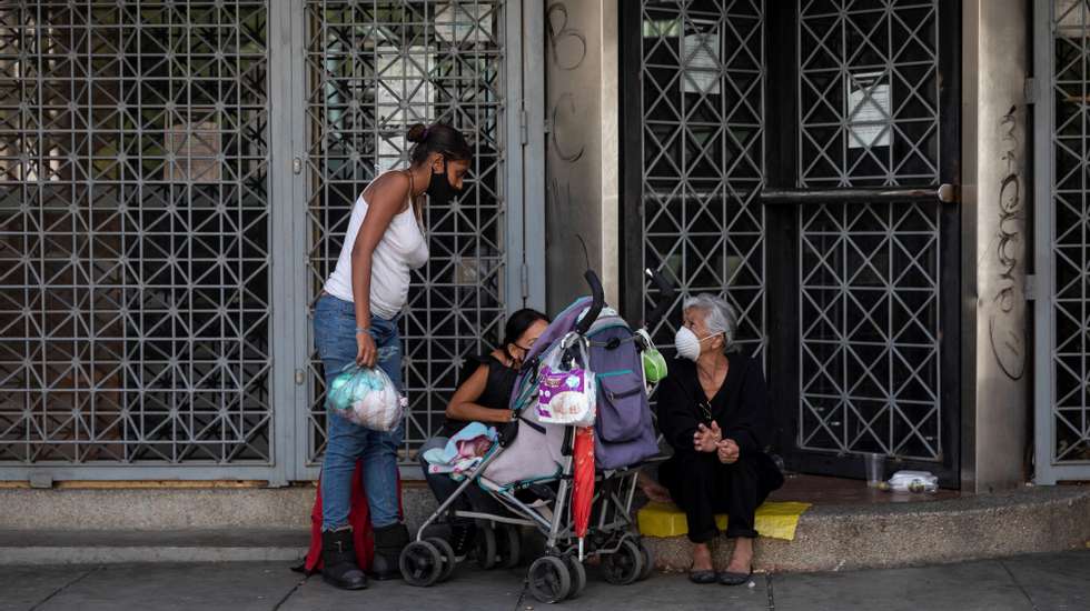 epa08933238 A group of people waiting for donations, in Caracas Venezuela, 06 January 2021 (issued on 12 January 2021). Thousands of Venezuelans go out to the streets every day to ask for money or food to eat, as the Caribbean country has been in the grip of an economic crisis for years.  EPA/RAYNER PEÃ‘A R